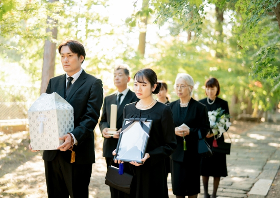 メモサのお葬式の松戸市での一日家族葬で遺影と骨箱を携え参列する家族