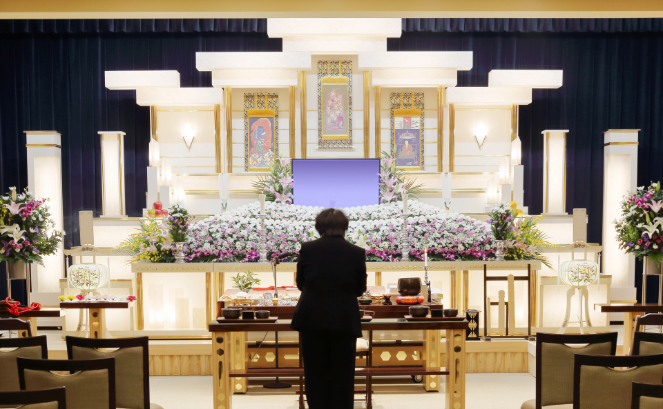 メモサのお葬式が松戸市で祭壇と花に囲まれた式場で事前相談を案内している